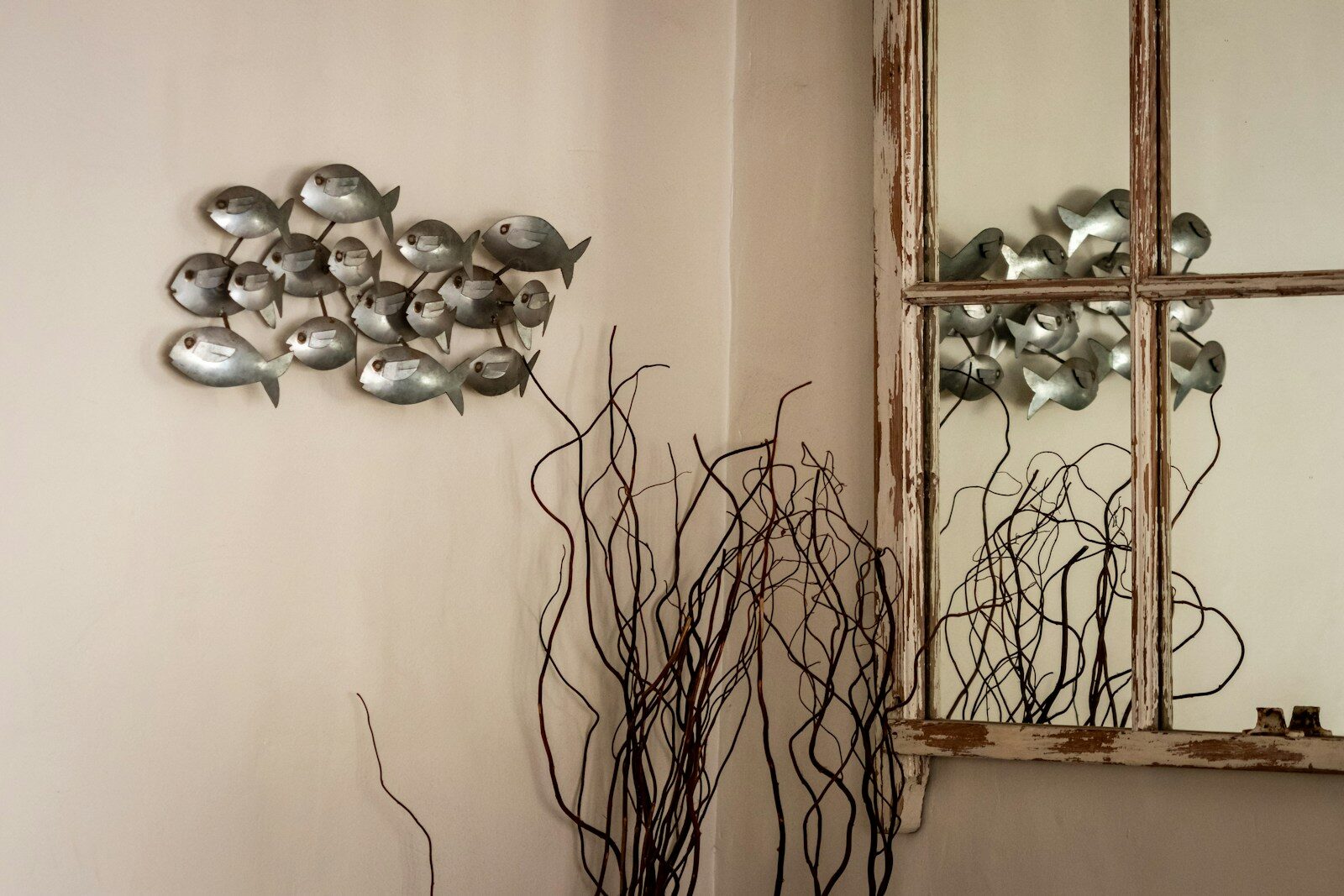 A room with a mirror and a vase on a table